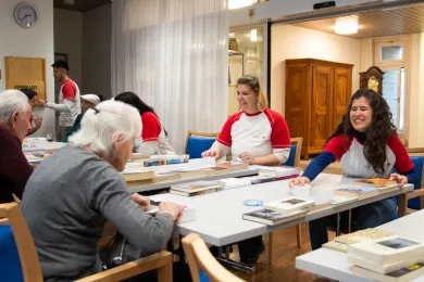 Junge Freiwillige spielen mit den älteren Personen vom Altersheim ein Spiel