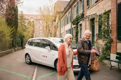 Eine Kundin vom Fahrdienst wird von einem Freiwilligen zu einem Termin begleitet.
