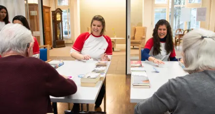Freiwillige vom Jugendrotkreuz spielen Spiele mit älteren Menschen im Altersheim